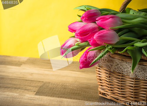 Image of Beautiful bouquet of pink tulips in a wicker basket