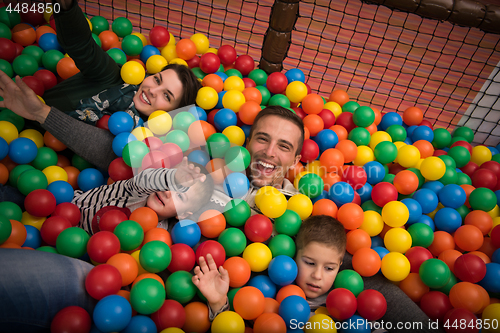 Image of young parents with kids in a children\'s playroom