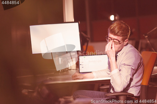 Image of man working on computer in dark office