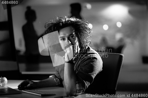 Image of man working on computer in dark office