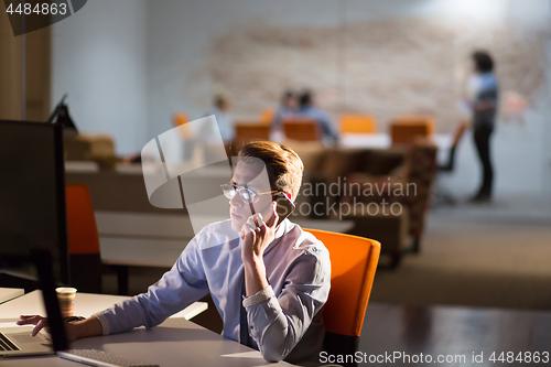 Image of man using mobile phone in dark office