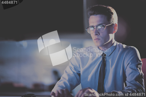 Image of man working on computer in dark office