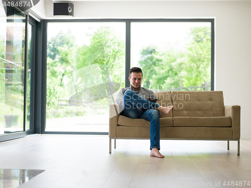 Image of man on sofa using tablet computer