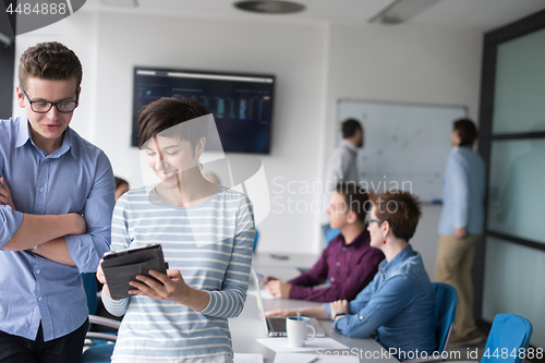 Image of Two Business People Working With Tablet in office