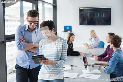 Image of Two Business People Working With Tablet in office