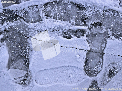 Image of Frozen pond surface with footprints close-up