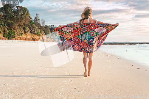 Image of Carefree girl walking along the beach early morning