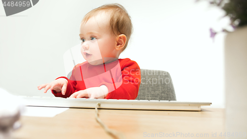 Image of Happy child baby girl toddler sitting with keyboard of computer isolated on a white background