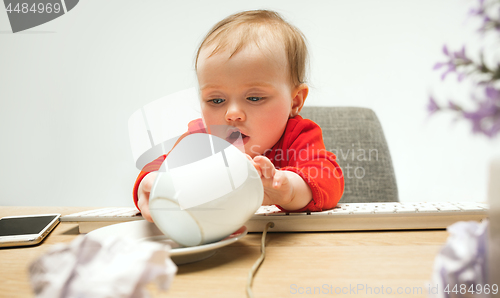 Image of Happy child baby girl toddler sitting with keyboard of computer isolated on a white background