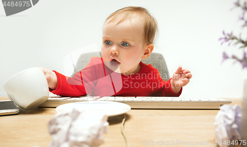 Image of Happy child baby girl toddler sitting with keyboard of computer isolated on a white background