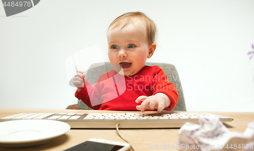 Image of Happy child baby girl toddler sitting with keyboard of computer isolated on a white background