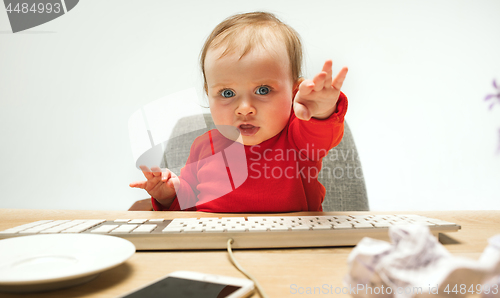 Image of Happy child baby girl toddler sitting with keyboard of computer isolated on a white background