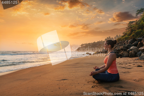 Image of Woman doing yoga at beach - Padmasana lotus pose