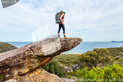 Image of Hiker on rock cliff precipice with views