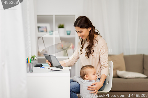 Image of mother student with baby and tablet pc at home