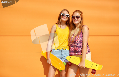 Image of teenage girls with short skateboards outdoors