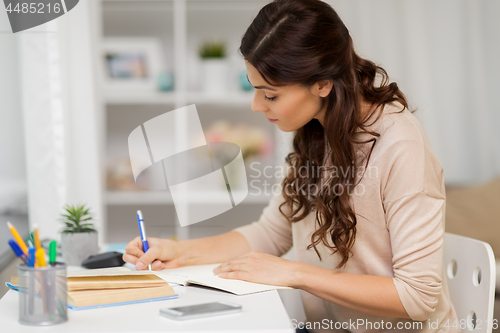 Image of female student with book learning at home