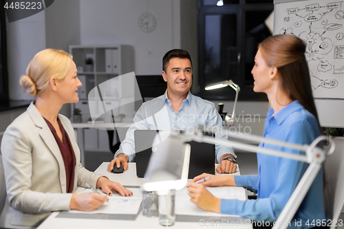 Image of business team working at night office