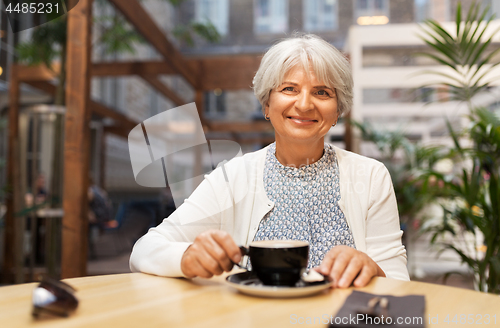 Image of senior woman with coffee at street cafe