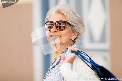 Image of senior woman in sunglasses with shopping bags