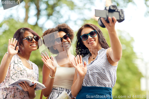 Image of women with map travelling and recording video blog