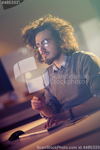 Image of man working on computer in dark office