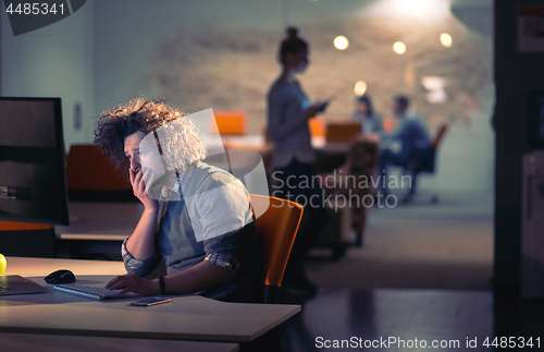 Image of man working on computer in dark office