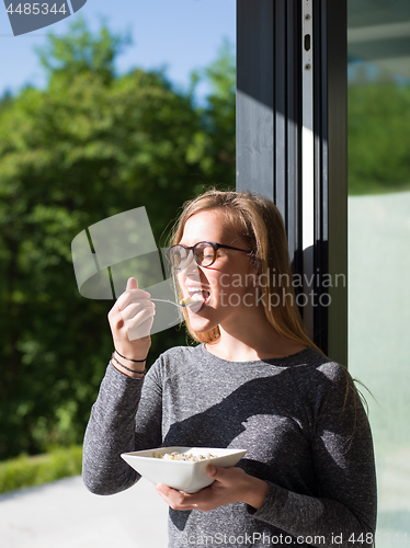 Image of woman eating breakfast in front of her luxury home villa