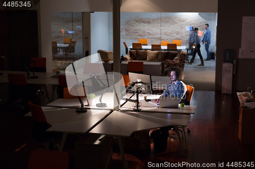 Image of man working on computer in dark office