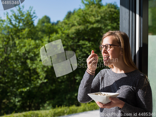 Image of woman eating breakfast in front of her luxury home villa