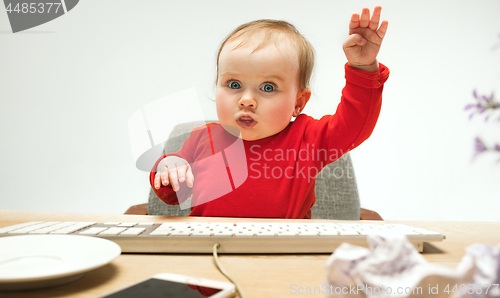 Image of Happy child baby girl toddler sitting with keyboard of computer isolated on a white background