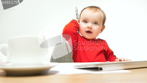 Image of Happy child baby girl toddler sitting with keyboard of computer isolated on a white background