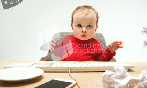 Image of Happy child baby girl toddler sitting with keyboard of computer isolated on a white background