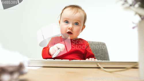 Image of Happy child baby girl toddler sitting with keyboard of computer isolated on a white background