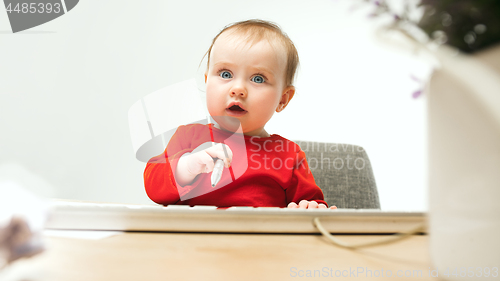 Image of Happy child baby girl toddler sitting with keyboard of computer isolated on a white background