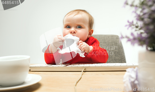 Image of Happy child baby girl toddler sitting with keyboard of computer isolated on a white background