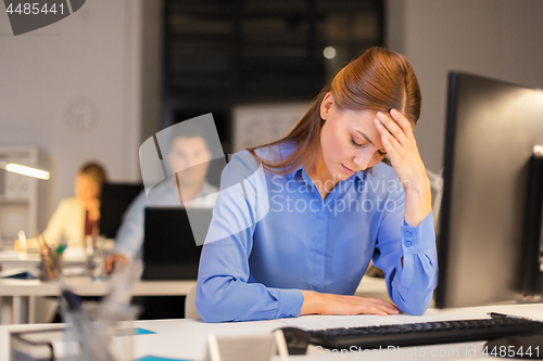 Image of businesswoman with computer at night office