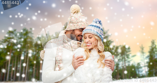 Image of couple hugging over winter forest background