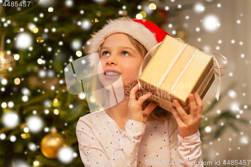 Image of smiling girl in santa hat with christmas gift