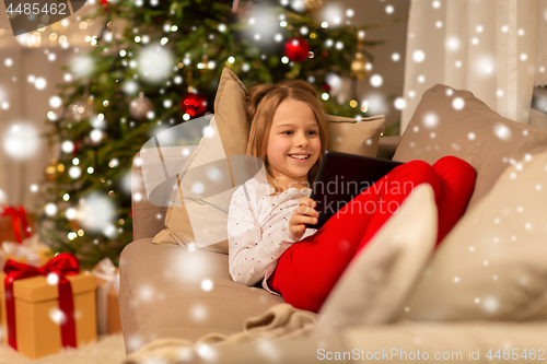 Image of smiling girl with tablet pc at christmas home