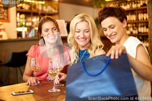 Image of women with shopping bags at wine bar or restaurant