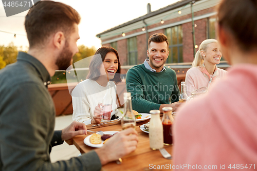 Image of friends having dinner or rooftop party in summer