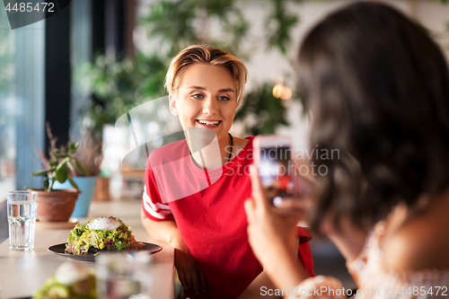 Image of women having lunch and photographing at cafe