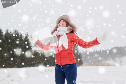 Image of happy woman in winter fur hat having fun outdoors