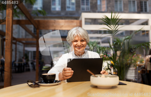 Image of senior woman with tablet pc and coffee at cafe