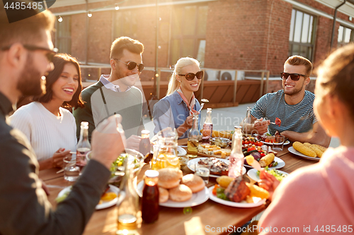 Image of friends having dinner or bbq party on rooftop