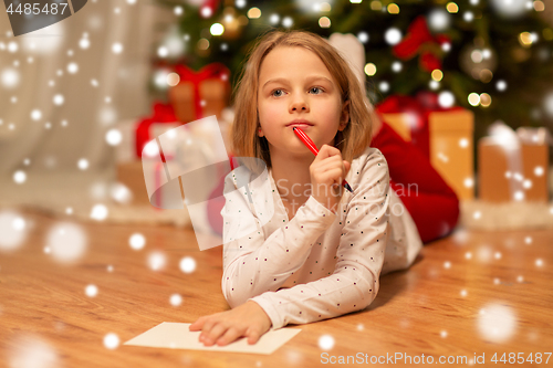 Image of girl writing christmas wish list at home
