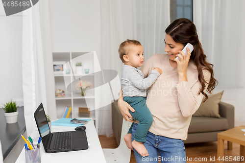 Image of mother with baby calling on smartphone at home