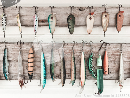 Image of Colorful fishing baits on a wooden wall