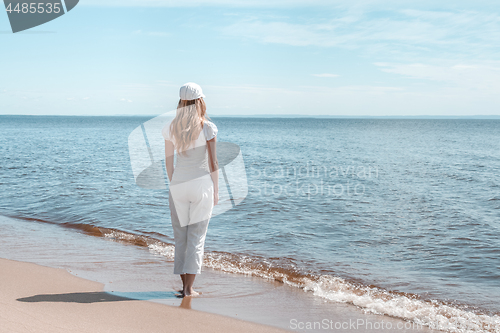 Image of Young woman in white looking at water